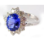 A tanzanite and diamond cluster ring, the natural oval tanzanite totalling approx 3.56cts overall, s