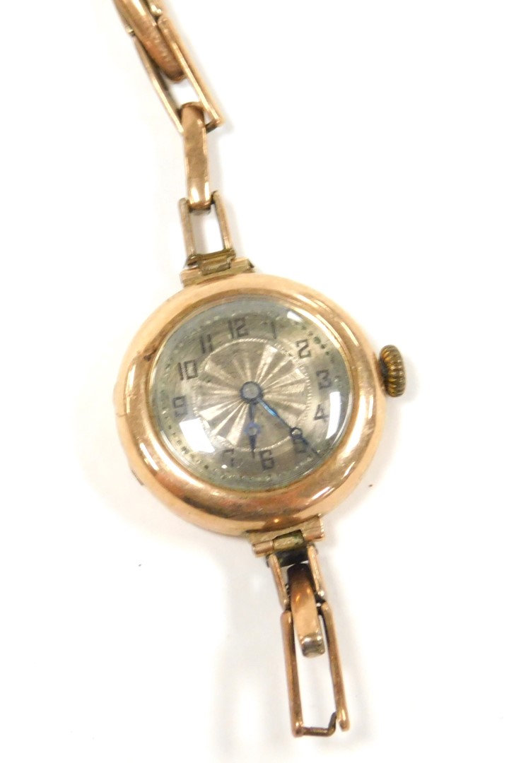 A wristwatch, with small circular silvered coloured dial in a yellow metal case, marked 375, on an e