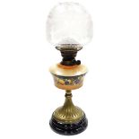 A Lambeth Works late 19thC oil lamp, the peach coloured glass reservoir decorated with flowers, on a