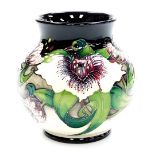 A Moorcroft limited edition vase, depicting cream and purple flowers on a black ground, signed Mary?