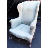 A 19thC wing back armchair, with ball and claw feet. (AF)