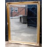A large rectangular gilt framed wall mirror, the corners each with shell scroll decoration and beade