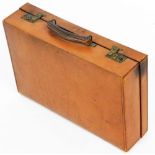 A tan leather travel case, bearing the initials CGM, 45cm wide.