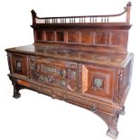 A Victorian mahogany Gothic style sideboard, the upper section with a scroll top held by shaped spin