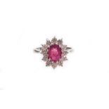 A 18ct white gold ruby and diamond cluster ring, the oval cut ruby totalling approximately 1.20cts,