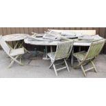 A wooden garden table, six chairs and parasol set, together with additional circular outdoor table a