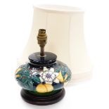 A Moorcroft squat table lamp, decorated with flowers and fruits, numbered to underside 249i, on a st