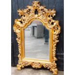 A modern gilt framed wall mirror, the gilt painted surround with various flowers and scrolled overal