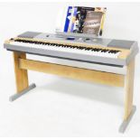 A Yamaha electric keyboard and stand, together with various music and accessories, in silvered colou