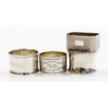 Four silver napkin rings, comprising an Edwardian silver napkin ring, engine turned, Birmingham 1905