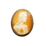 An early 20thC shell cameo brooch, depicting a figure head and shoulders profile, in a yellow metal