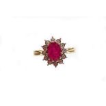A ruby and diamond cluster ring, with central oval ruby totalling approximately 1.61cts, surrounded