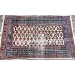 A Middle Eastern bordered rug, with geometric central panel and traditional stylised motifs in blue