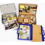 A collection of fly tying materials and equipment, including tying vice, a case of threads and capes