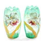 A pair of Victorian opaque glass vases, on a turquoise ground hand painted with lilies and foliage,