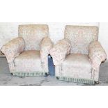 A pair of early 20thC armchairs, upholstered in floral material, on cream ground, with tassel fronts