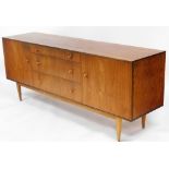 A 1960s teak sideboard, centred by three graduated drawers, flanked by cupboards on square tapering