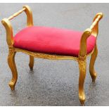 A French style gilt framed window seat, with floral carved decoration, painted in gold with a red cu
