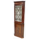 A late 19thC flame mahogany corner cabinet, the top with single astragal glazed doors, cupboard base