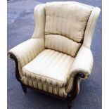 A mahogany framed armchair, with green and gold striped fabric upholstery, on scroll carved handles,