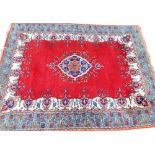 A large 20thC woollen machine woven rug, of rectangular form, floral geometric pattern on blue and o