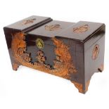 A heavily carved mid 20thC camphor wood chest, set with various panels of Oriental figures and build