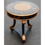 A painted circular side table, in the French style painted in gold and black, on tripod scroll base,
