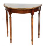 A 20thC mahogany and flame mahogany finished demi lune table, with a glass top raised above cylindri