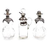 A pair of cut glass and silver topped liqueur decanters, each with embossed stopper and flared rims,