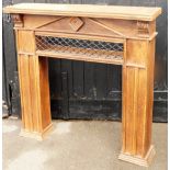 An oak fireplace surround, with carved leaf finials and metal cross section, on two plinth columns,