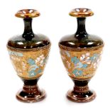 A pair of Royal Doulton Lambeth Stoneware vases, with a brown and green mottled glaze and floral cen