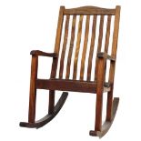 A modern teak stained slatted rocking chair, with curved cresting rail, vertical shaped back splat a
