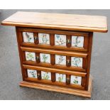 A pine novelty cabinet, the elongated rectangular top above three drawers each set with four ceramic
