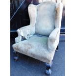 A 19thC wing back armchair, with ball and claw feet. (AF)