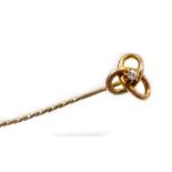 A knot design stick pin, set with single tiny diamond in claw setting with three tier knot on pleate