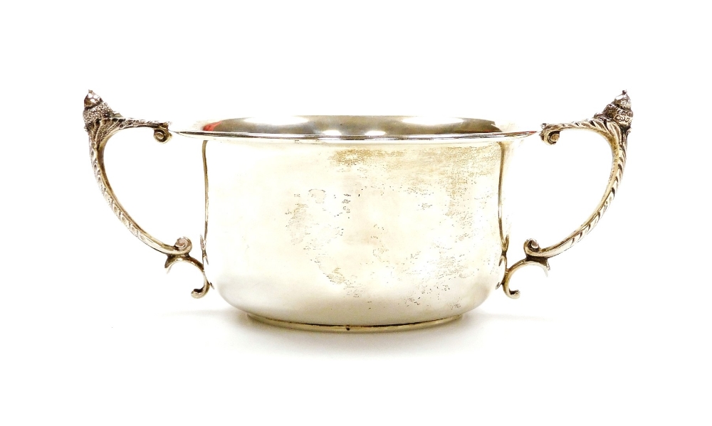 A George V silver trophy cup, the plain circular bowl with angular leafy handles surmounted by acorn