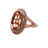 A rose gold oval peach morganite and double halo dress ring, with diamond set shoulders, the morgani