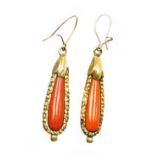 A pair of early to mid 20thC coral drop earrings, each with tear drop shaped coral centre and a gold