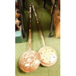 Two Victorian copper warming pans, each with pierced overall design, on wooden handles.