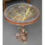 An oriental style resin table, carved to depict a horse and carriage in a field, on scroll elephant