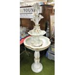 A ceramic three tier decorative fountain, the top with lilies on a three splayed bowl supported by t