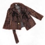 A brown half length fur jacket, unlabelled with a black petal design lining.