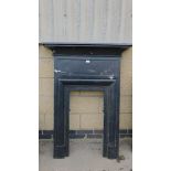 A black painted cast metal fire surround, 132cm high, 97cm wide, 18cm deep.