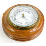 An early 20thC circular aneroid barometer, in an oak case, 20cm diameter.