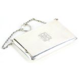 A George V silver purse, engraved with monogram, the interior lined in green fabric, suspended with