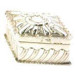 A late Victorian lozenge shaped trinket box, embossed with scrolls, within a shaped border and base,