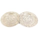 A pair of Eastern white metal plates, each with pierced and engraved decoration of animals, trees, l