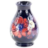 A Moorcroft baluster shaped vase, decorated with a band of poppies, on a blue ground, impress mark t