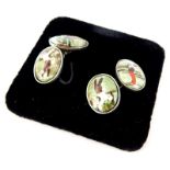 A pair of silver golfing related cufflink's, each depicting figures golfing, on silver backing with
