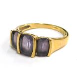 A 9ct gold dress ring, set with three oval cut amethyst, in a modern staged ring setting, ring size